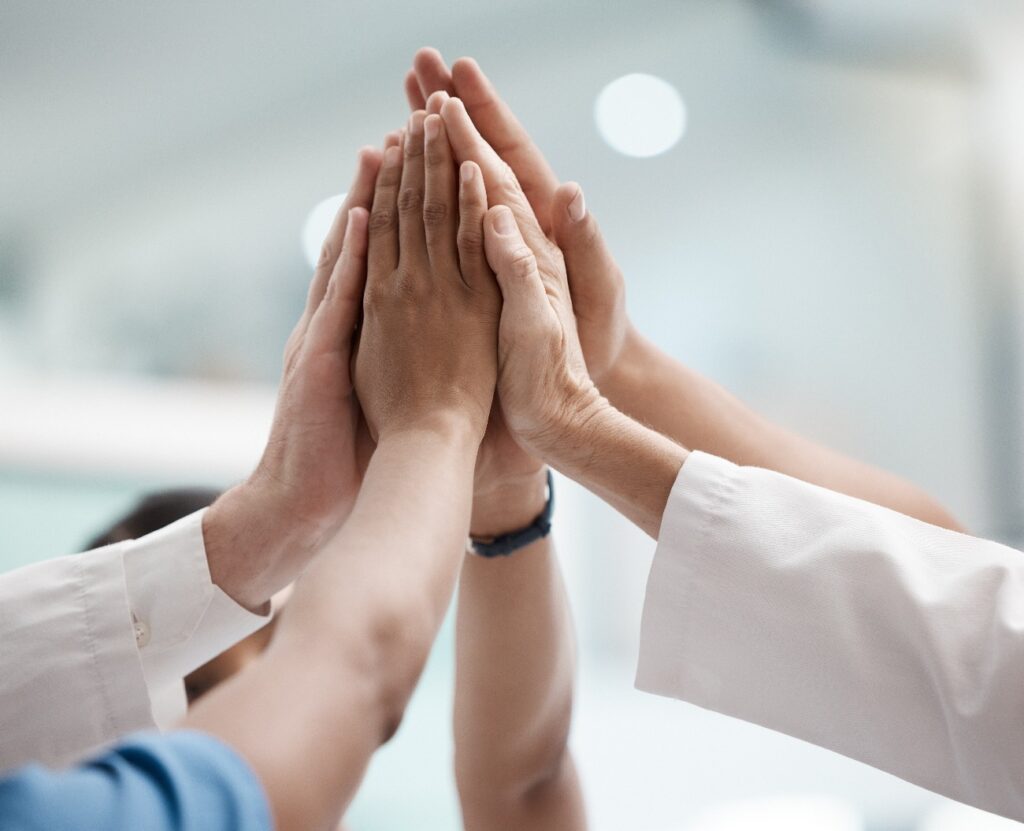High Five, Teamarbeit und Ärzte, die gemeinsam an einer Mission, einem Ziel oder der Teambildung arbeiten. Denkweise, Zielsetzung oder medizinische Gruppe, geprägt von Vertrauen, Motivation und Unterstützung für eine Vision, den Sieg oder den Erfolg.