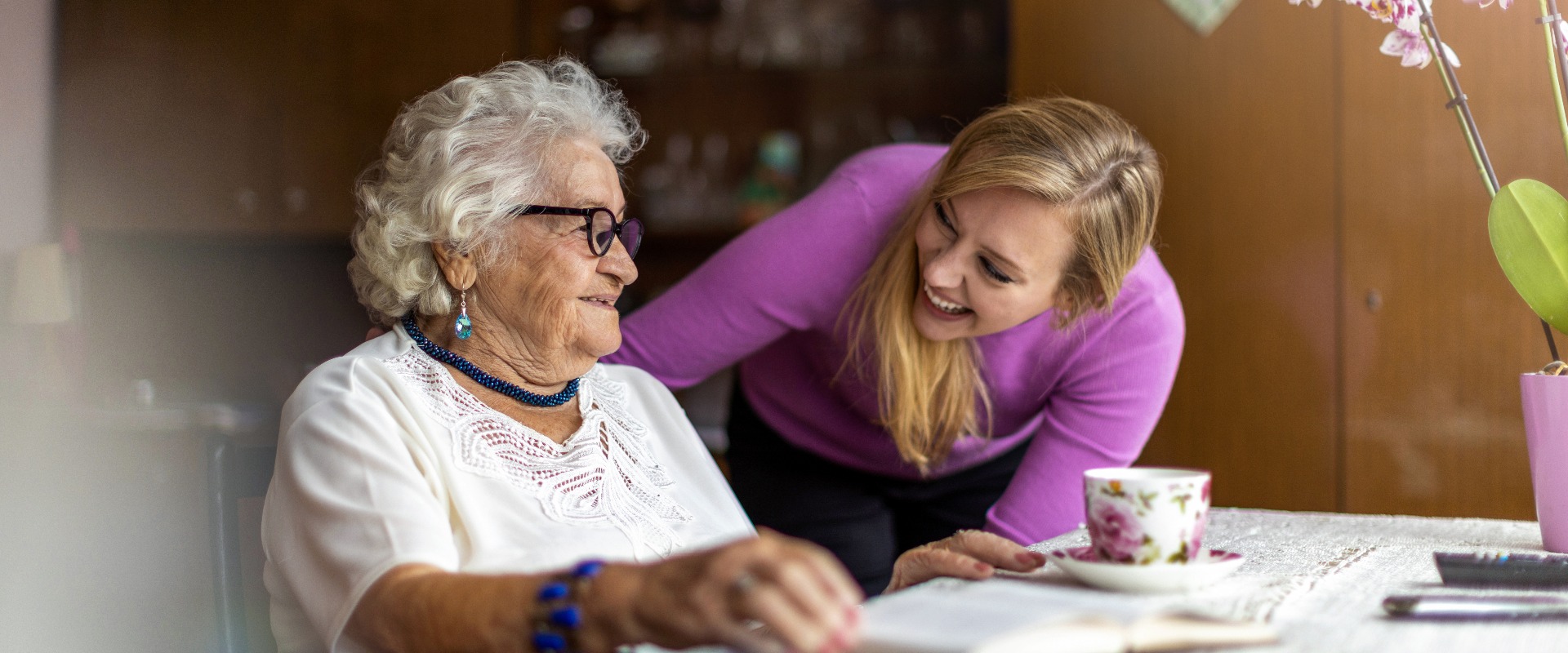 Young woman spending time with her elderly grandmother at home